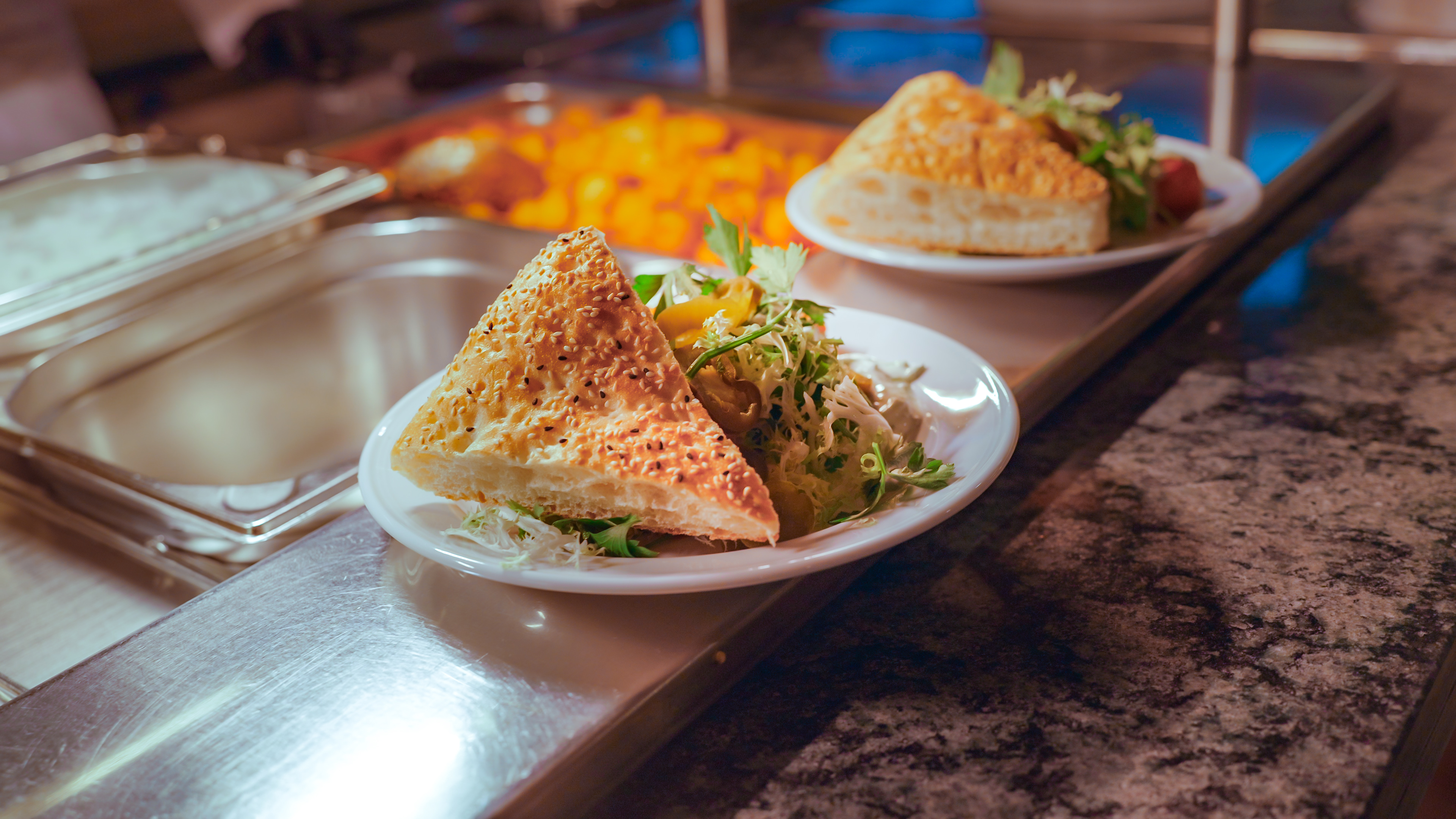 Auf einem liegt ein Stück Fladenbrot und Salat