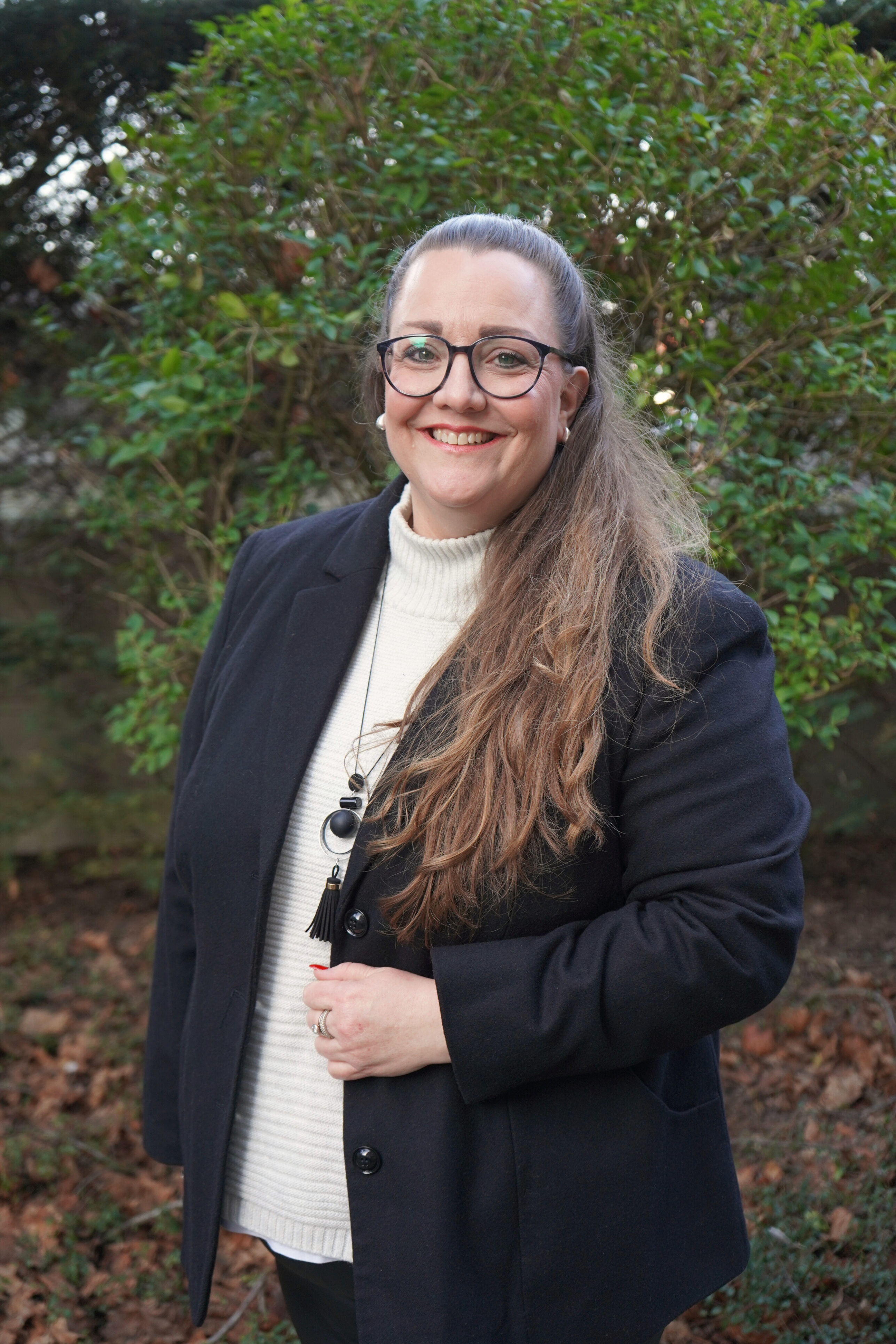 Weibliche Person mit langen braunen Haaren und einer Brille