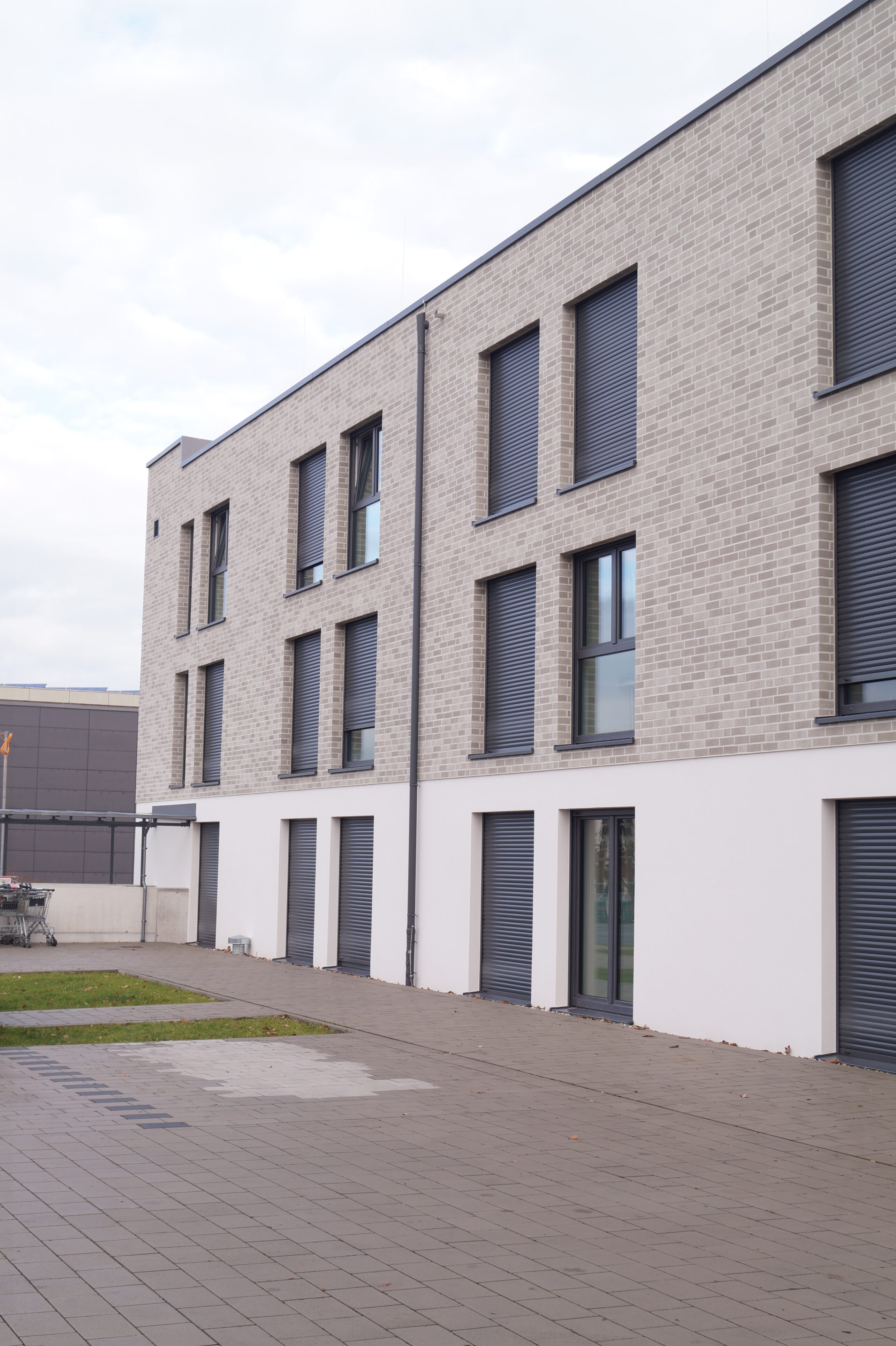 A modern building with a light-coloured façade and flat roof