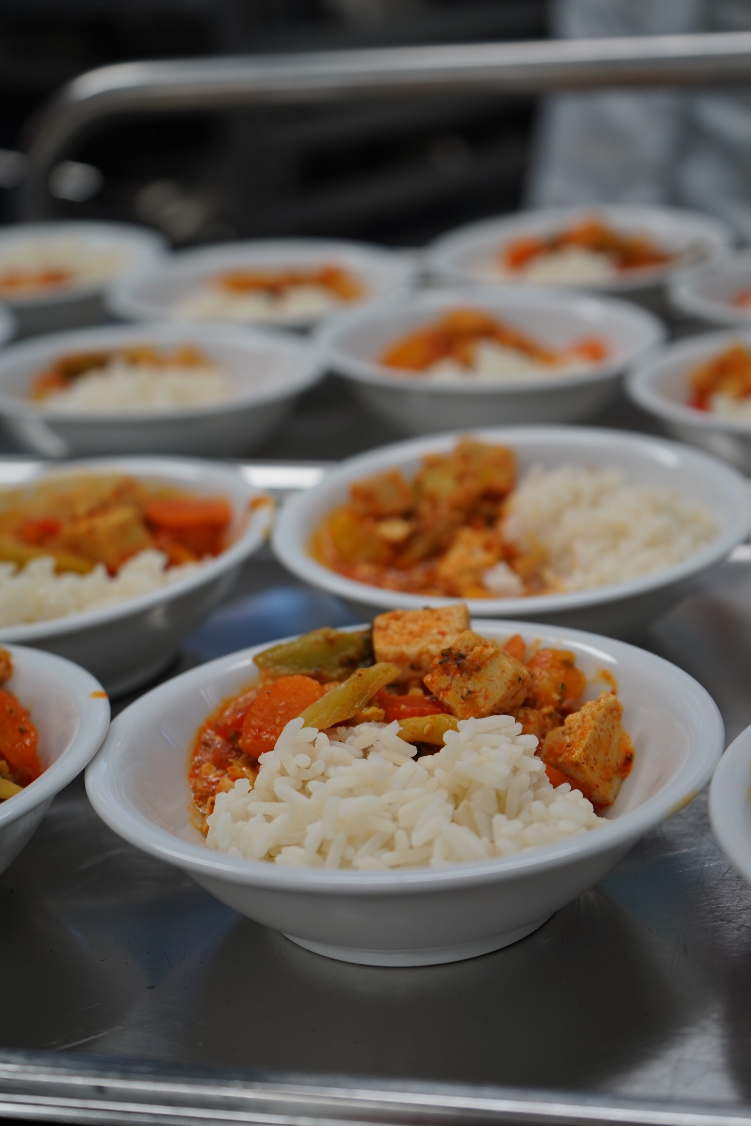 On a silver serving trolley are small bowls containing rice and vegetables