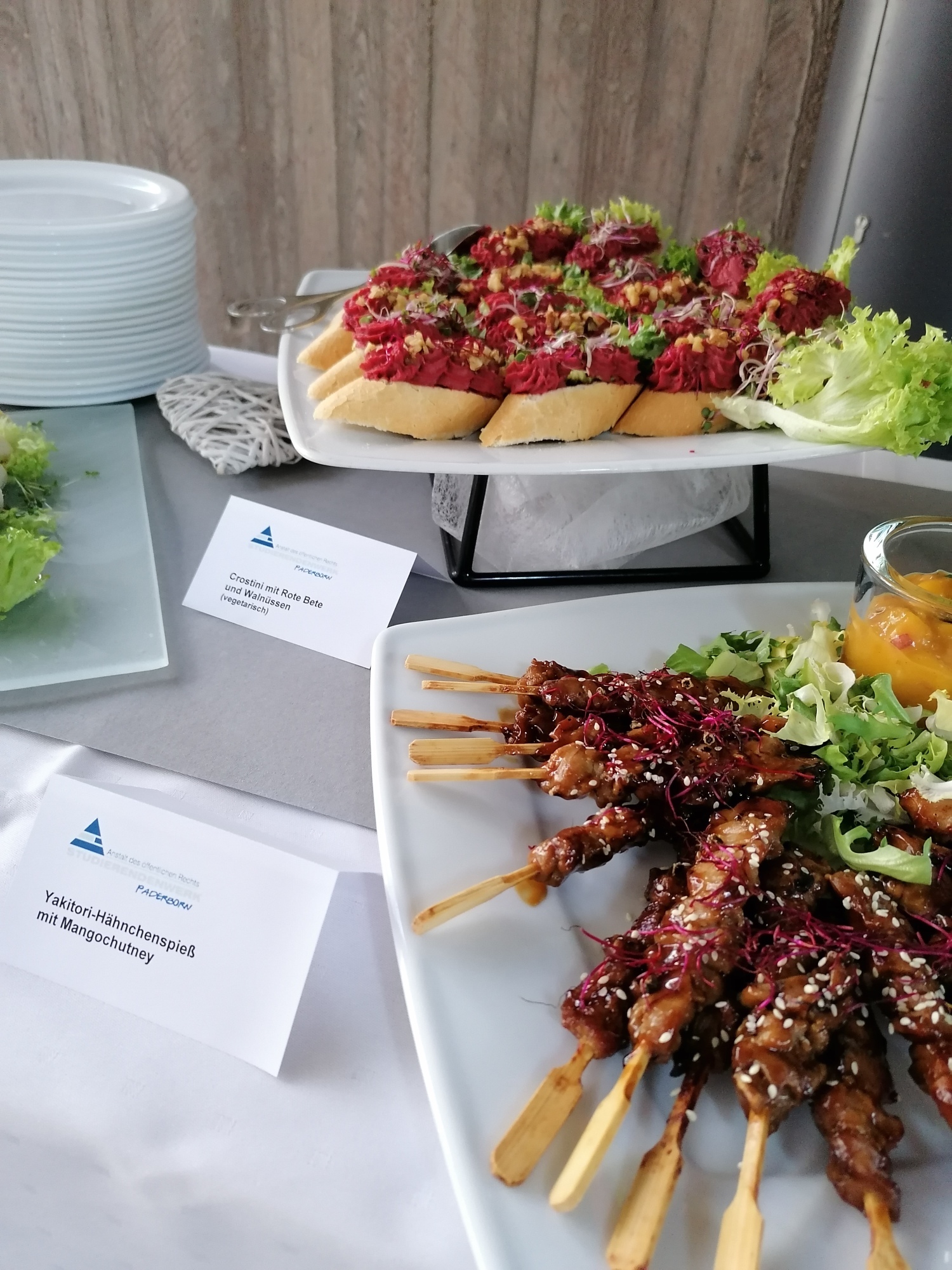 Ausschnitt eines Buffets mit verschiedenen Speisen in Gläsern oder auf Tellern angerichtet, z.B. Spieße und Baguettes