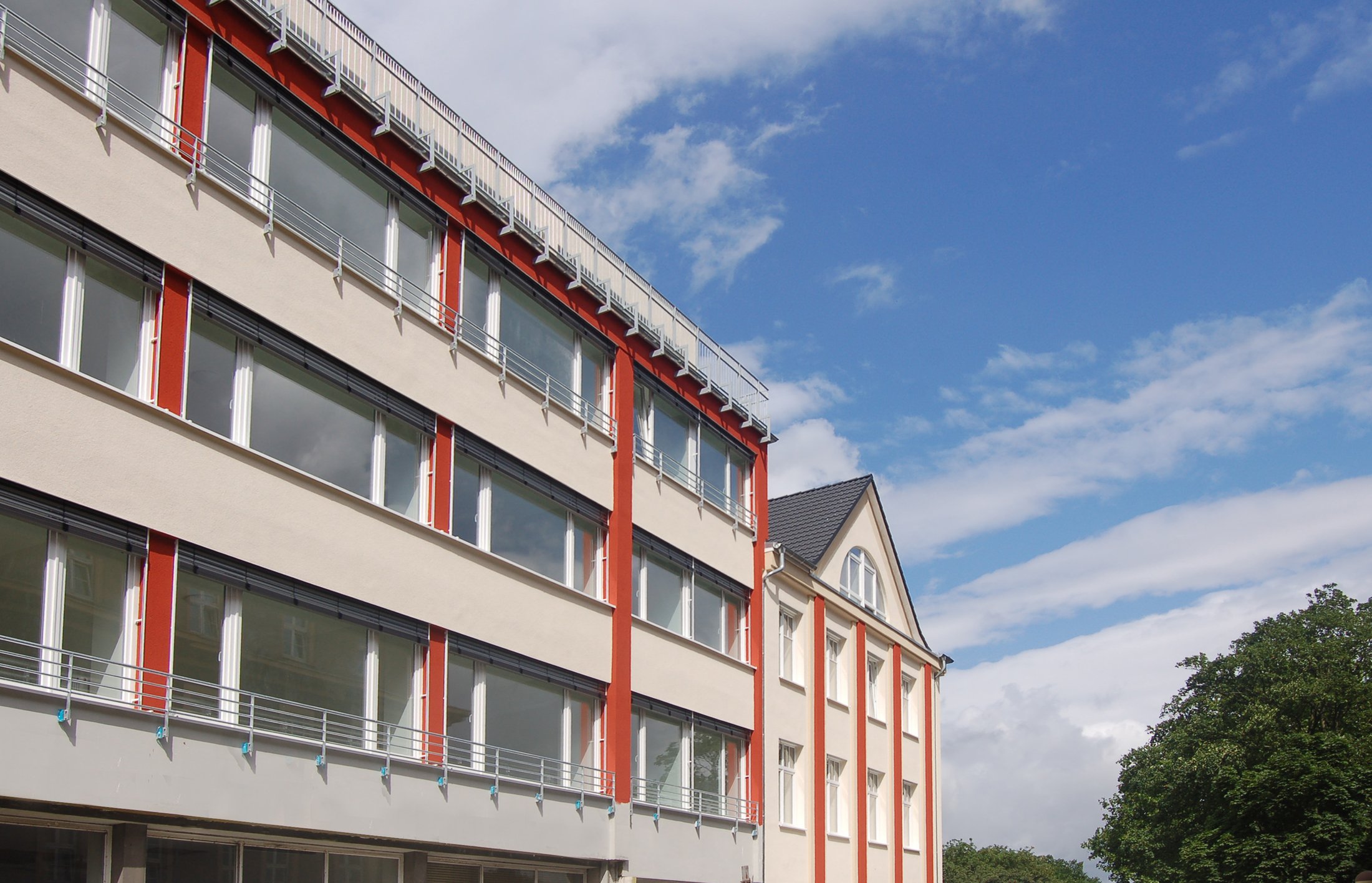 Studierendenwohnheim in Hamm mit modernen Fassaden und großen Fenstern unter blauem Himmel.