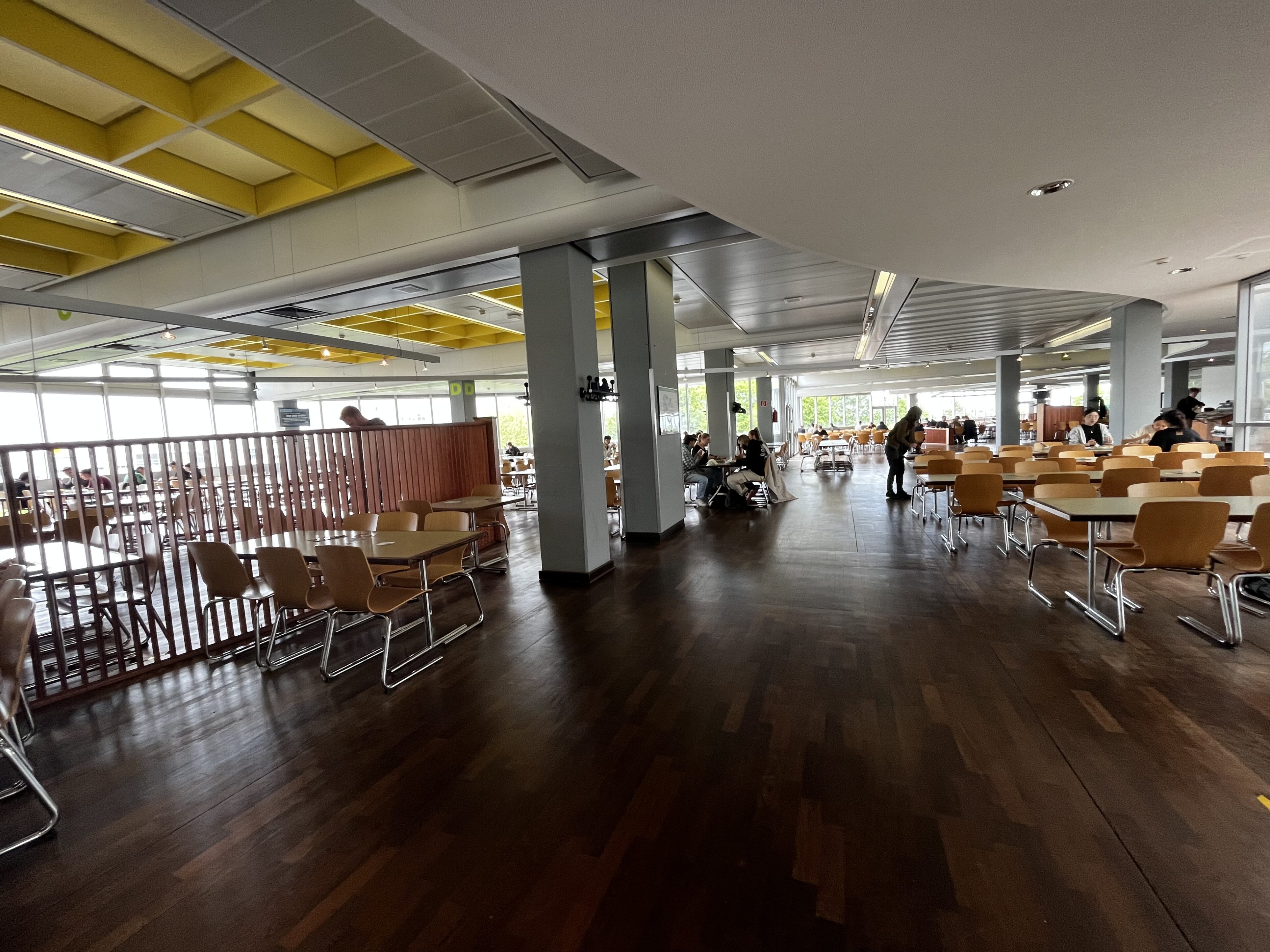 Weitläufiger Sitzberreich mit Tischen und Stühlen in einer Mensa