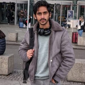 Eine männliche Person mit Bart und Kopfhörern um den Hals