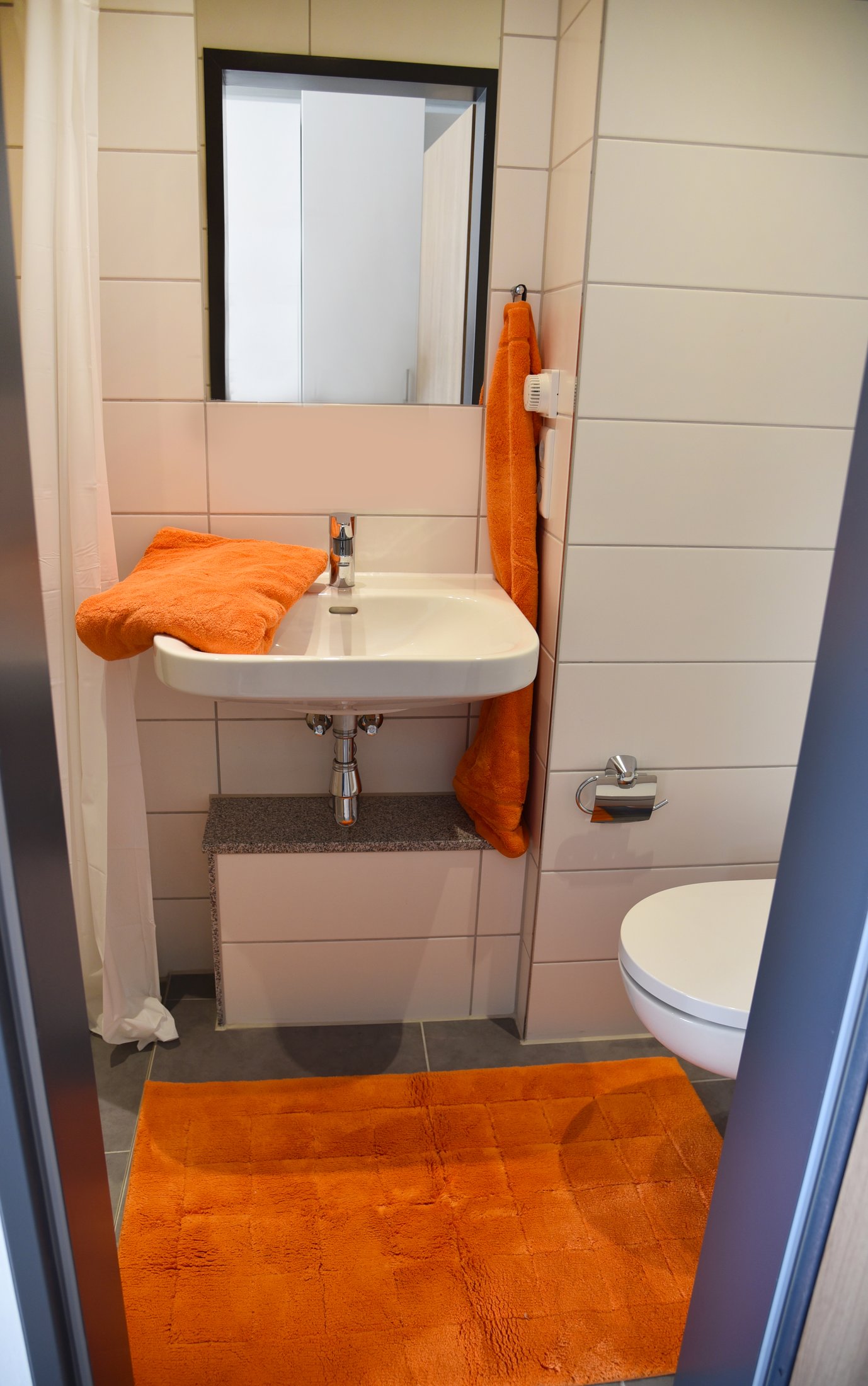 Bathroom in the Paderborn-Peter_Hille_Weg_11 student hall of residence, modern and with orange accents.