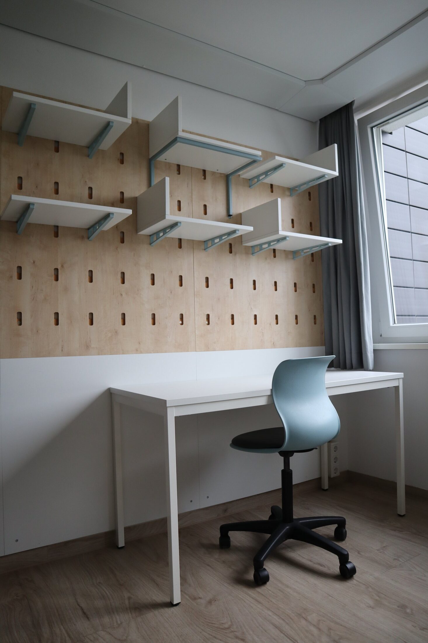 Studierendenwohnheim in Paderborn-Peter_Hille_Weg_13: Modernes Zimmer mit Schreibtisch, Stuhl und Holzfußboden.